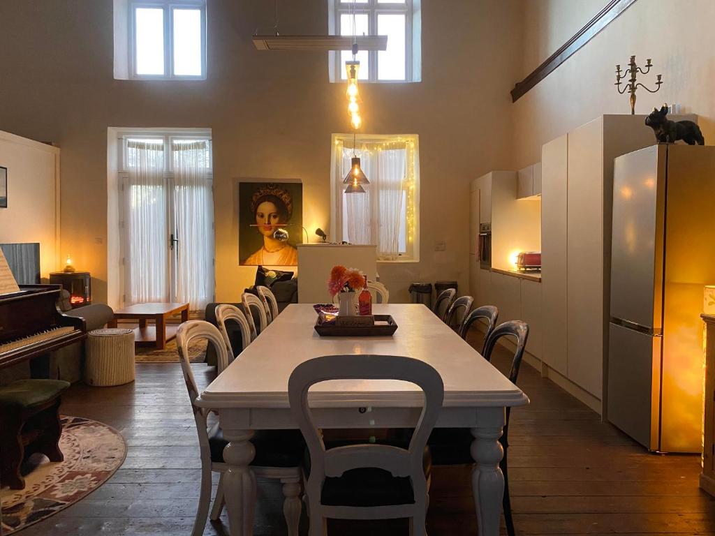 a dining room with a table and chairs at Creative Norfolk Chapel with Piano and Sauna Sleeps 10 in Briston