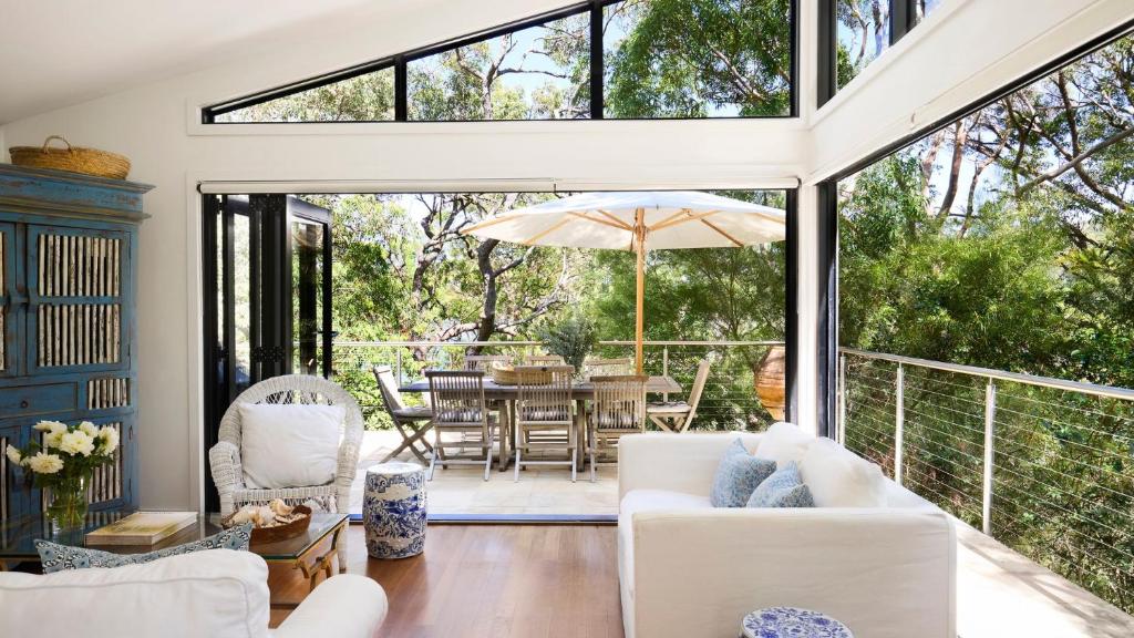 a living room with white furniture and a large window at Pittwater Hideaway in Palm Beach