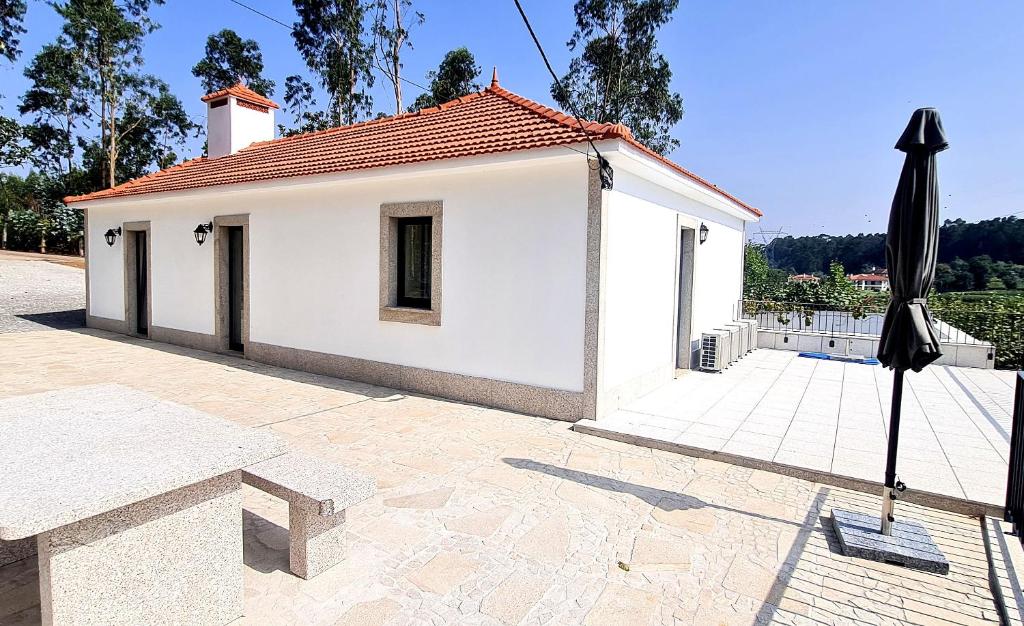 a small white building with a roof at Quinta da Toqueira in Canedo