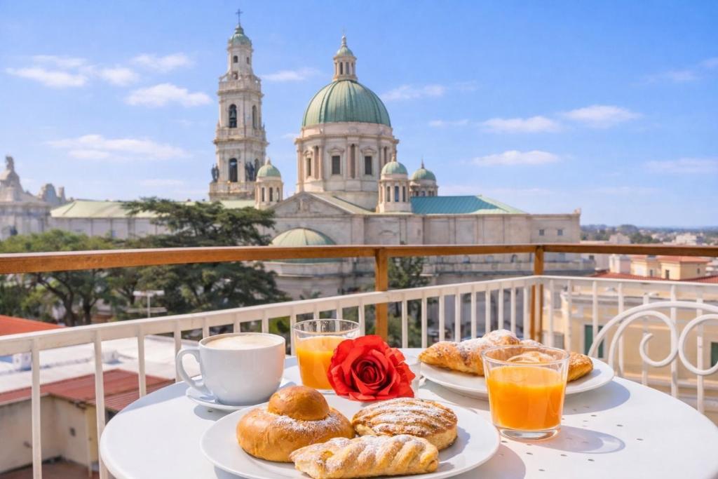 a table with two plates of pastries and two glasses of orange juice at Aurum Pompei Suites in Pompei