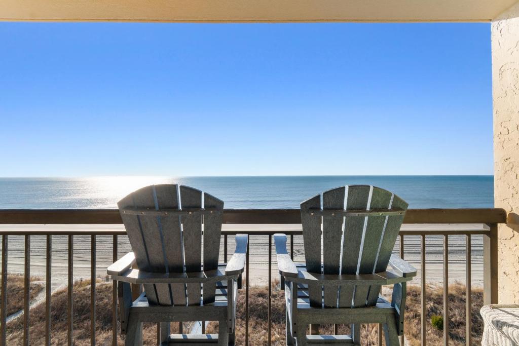 two chairs sitting on a balcony looking out at the ocean at Oceanfront 1BR Condo with Corner Balcony Pool in Myrtle Beach