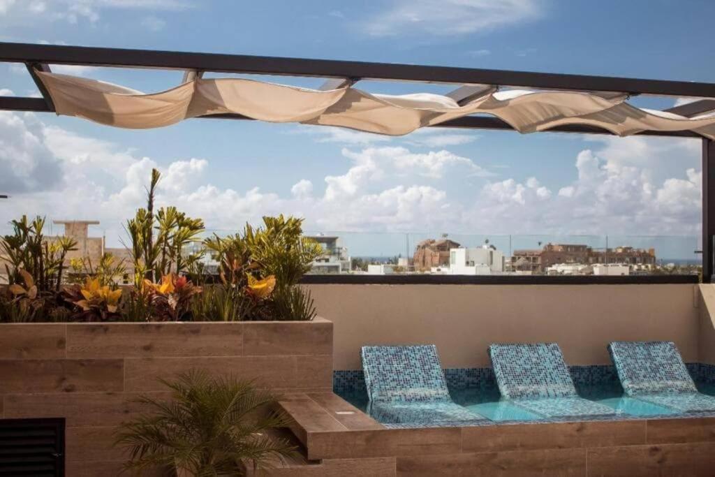 two chairs on a balcony with a view of the city at Beachside Studio & Jacuzzi Bliss in Playa del Carmen