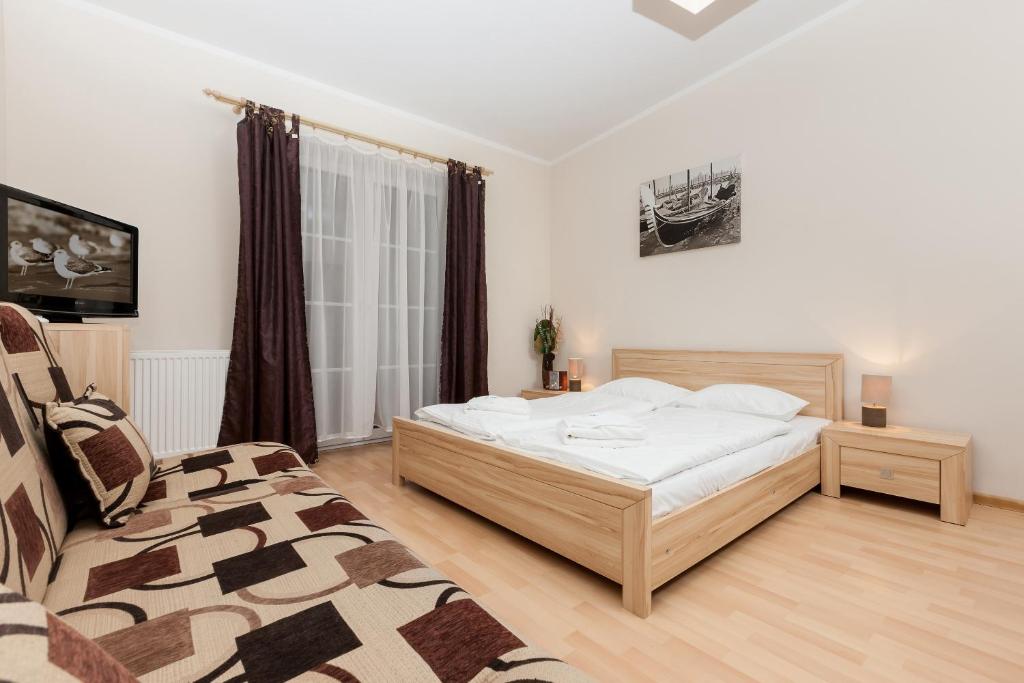 um quarto com uma cama e uma cadeira em Apartamenty Regina Maris em Świnoujście