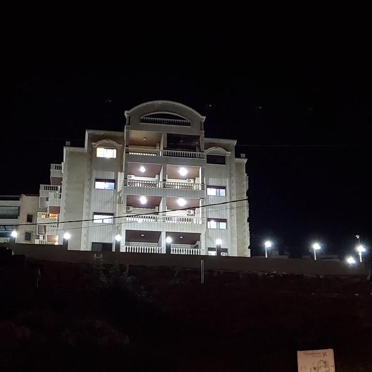 a large white building at night with lights at Paradise Palms Vacation Rentals in Mīdān az Zīr