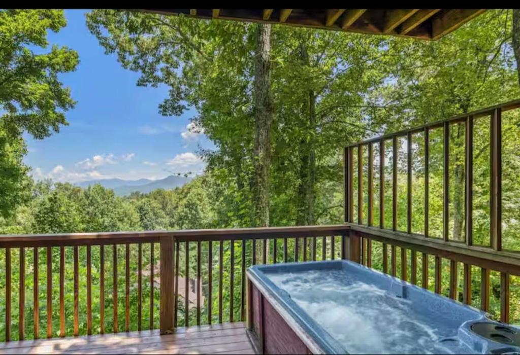 a hot tub on a wooden deck with trees at Fall Season Mtn Views, Hot Tub, Sauna, close to Downtown! in Gatlinburg