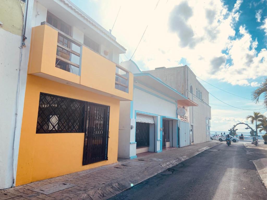 a yellow and white building on the side of a street at Casa Alberto Cozumel in Cozumel