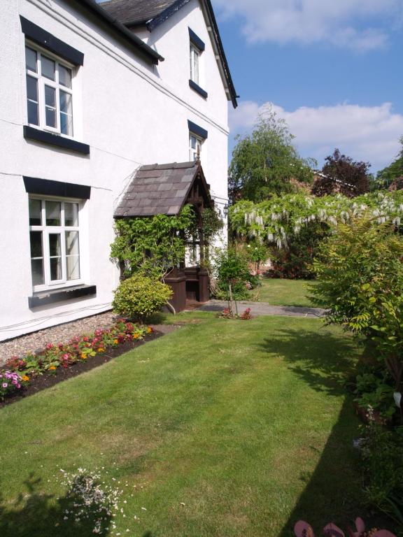 uma casa branca com um jardim e um gazebo em Church End Farm Bed and Breakfast em Hale