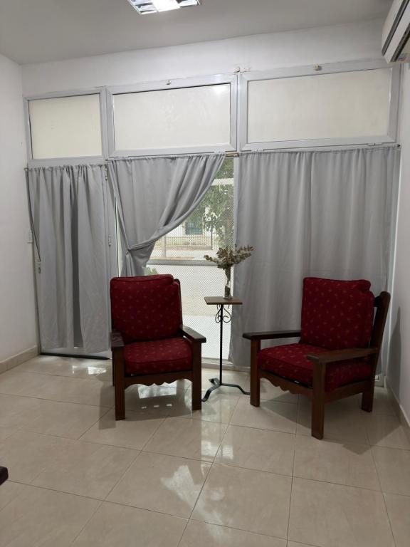 two chairs and a table in a room with windows at Apart Sur Catriel in Catriel