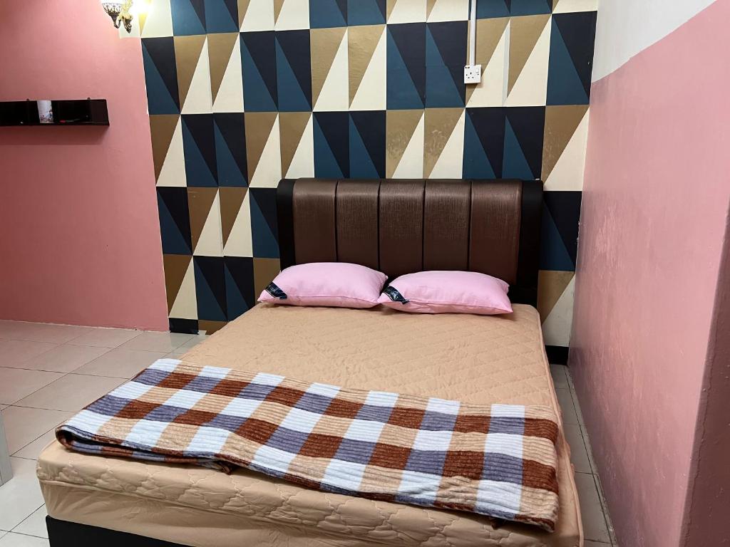 a bed with two pink pillows in a room at Homestay Adelia SI in Seri Iskandar