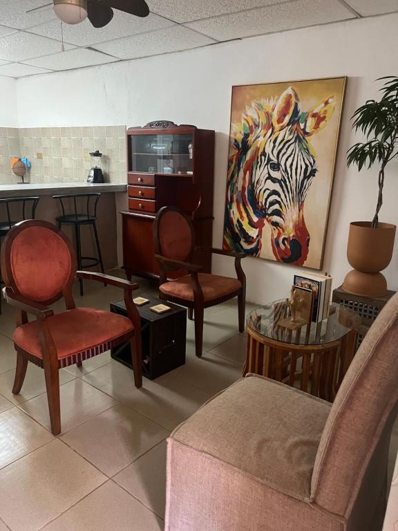 a room with chairs and a painting of a zebra at Pumila House in Villa Rosario