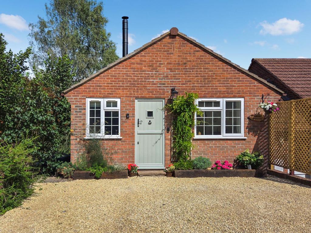 a brick house with a white door and window at Hillside Hideaway in Flaxley