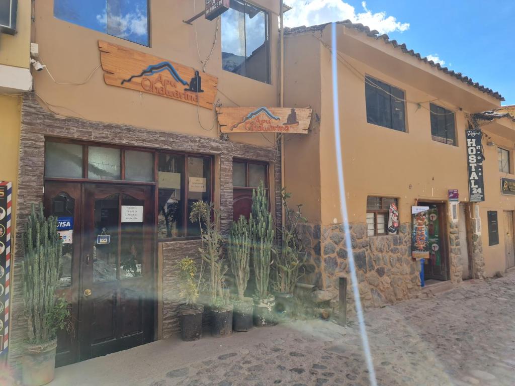 a building with potted plants in front of it at Hostal Apu Qhawarina - Ollantaytambo in Ollantaytambo