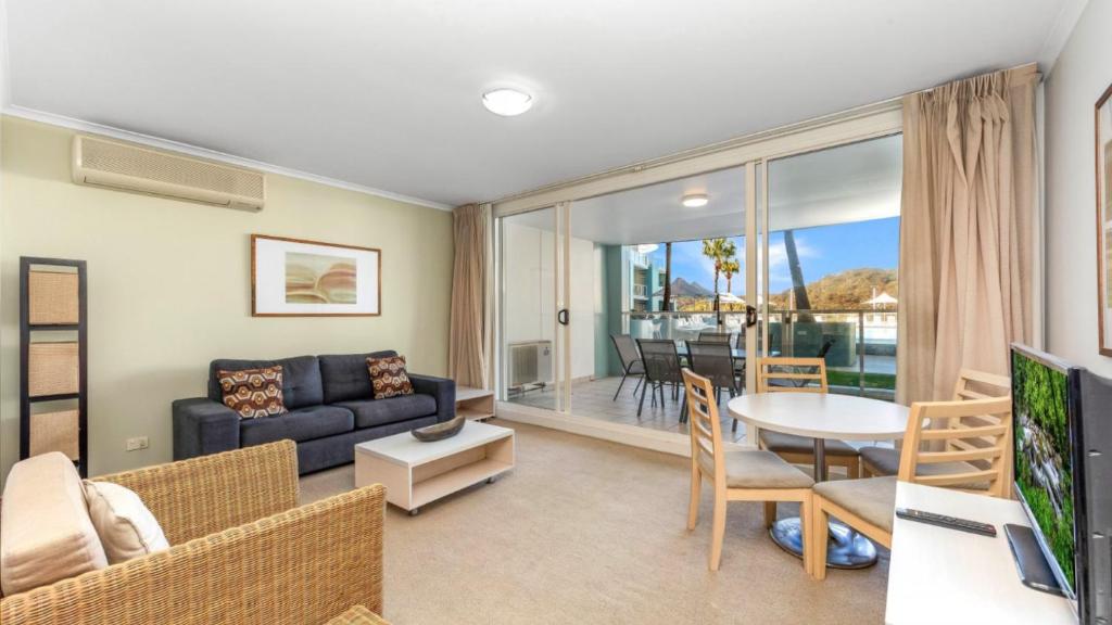 a living room with a couch and a table at Pool Delight - Ettalong Beach Resort in Ettalong Beach