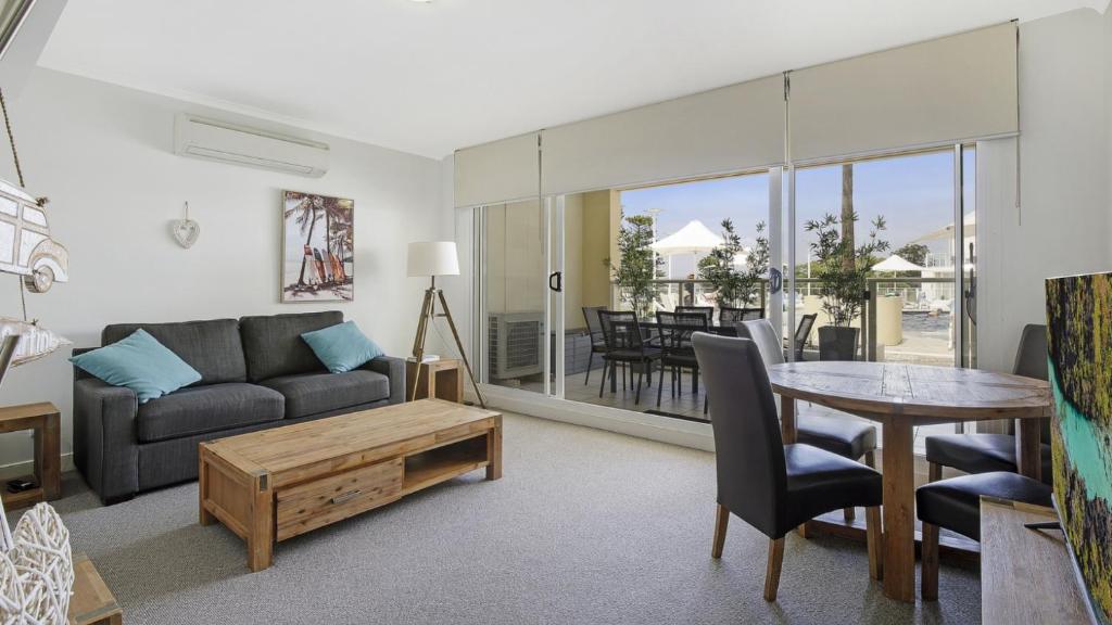 a living room with a couch and a table at Poolside Paradise Ettalong Beach Resort in Ettalong Beach