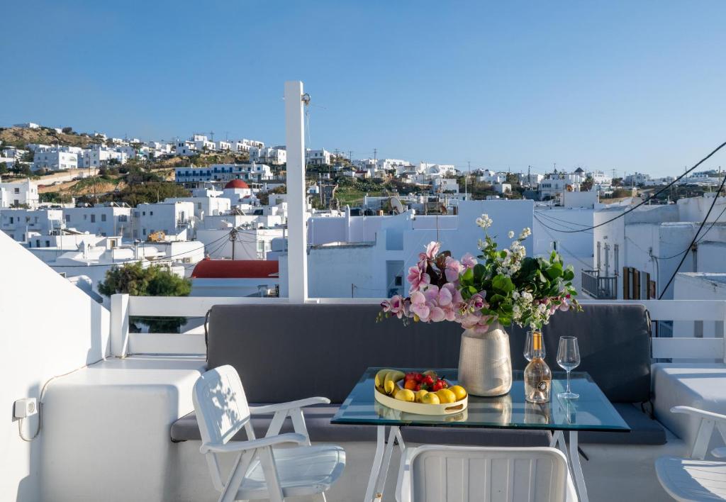 a table with fruit and flowers on a balcony at Mykonos Town Aura Panorama with Private Terrace in Megali Ammos