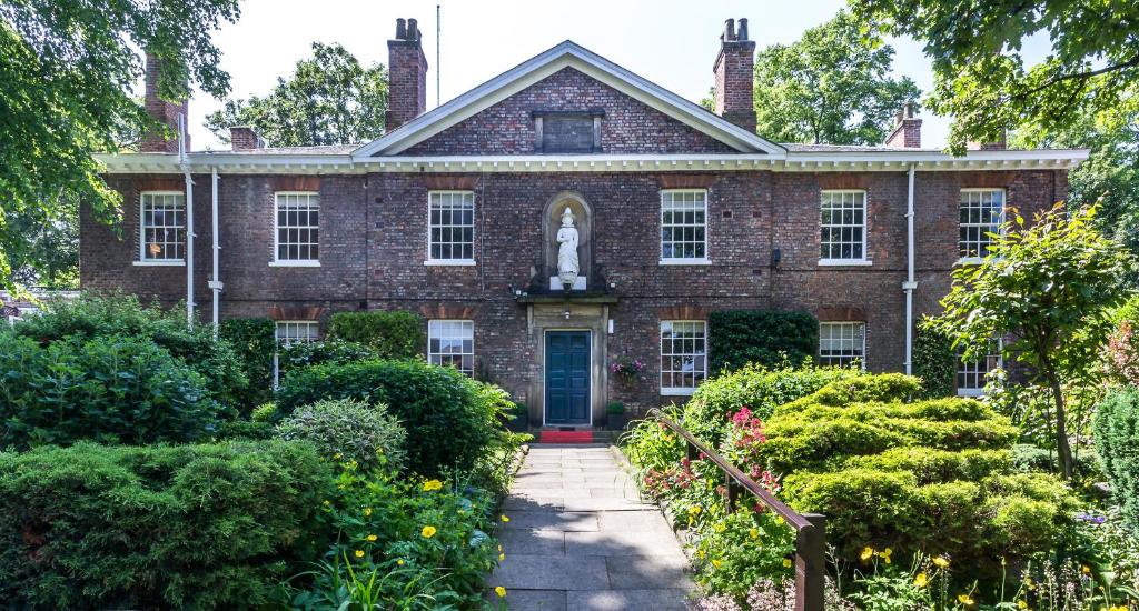 uma velha casa de tijolos com uma estátua no jardim da frente em Middletons em York