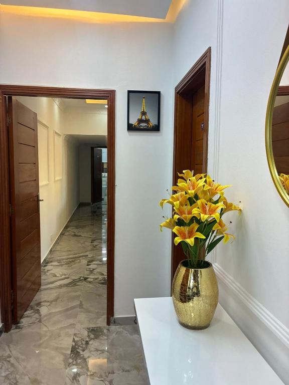 a vase with yellow flowers on a table in a hallway at vk-appart in Maianga