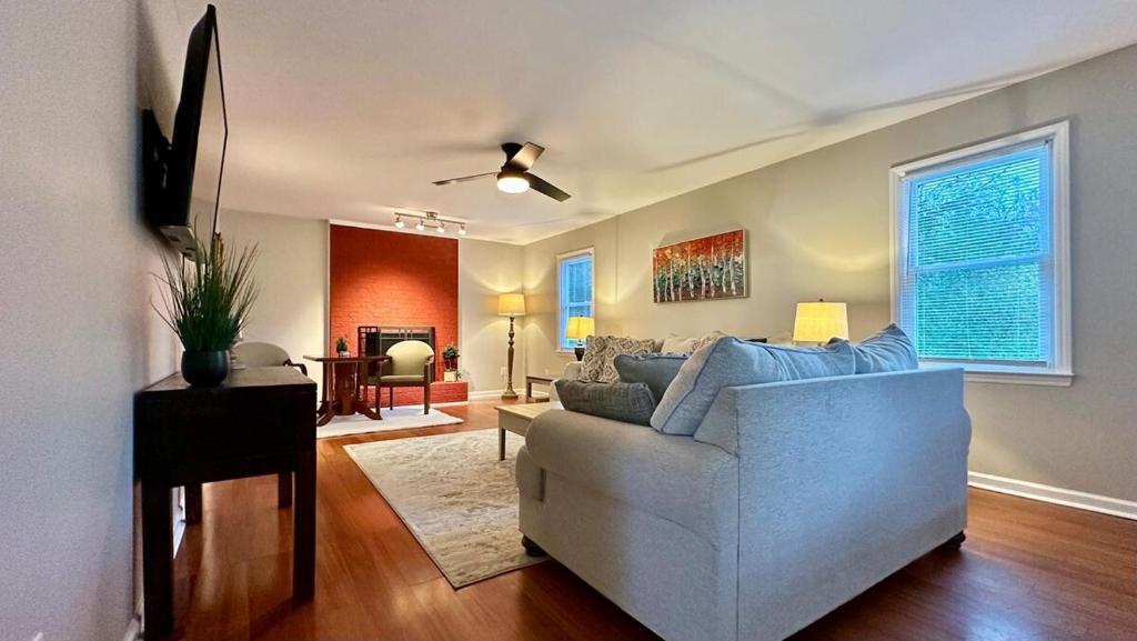 a living room with a white couch and a tv at 2200SQFT Coastal home on half Acre in Jacksonville
