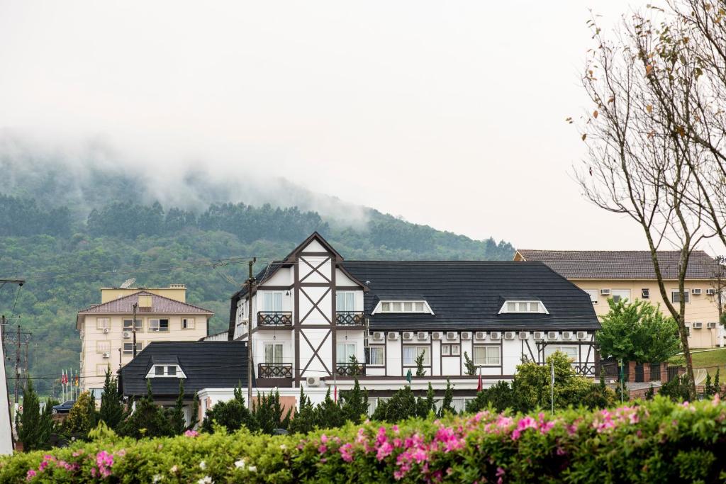 a black and white building with a mountain in the background at Baviera Park Hotel in Teutônia
