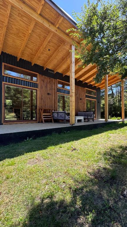 a house with a wooden roof on a yard at Refugio en Malalcahuello in Malalcahuello