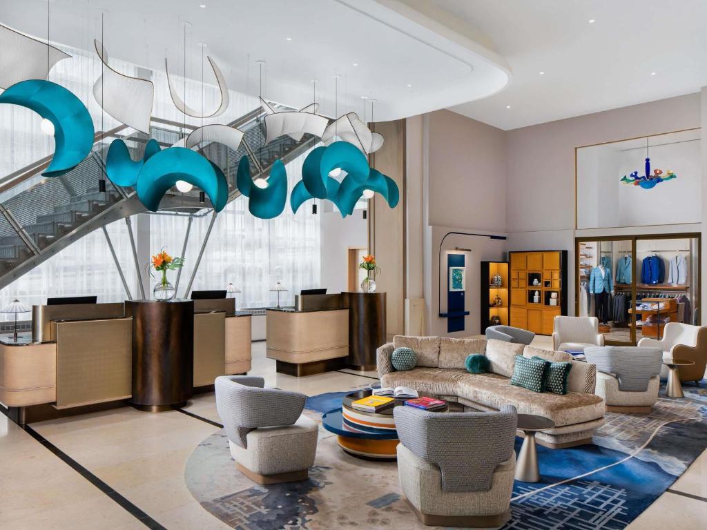 ein Wohnzimmer mit Sofa, Sesseln und einem Kronleuchter in der Unterkunft Sofitel Montreal Golden Mile in Montreal