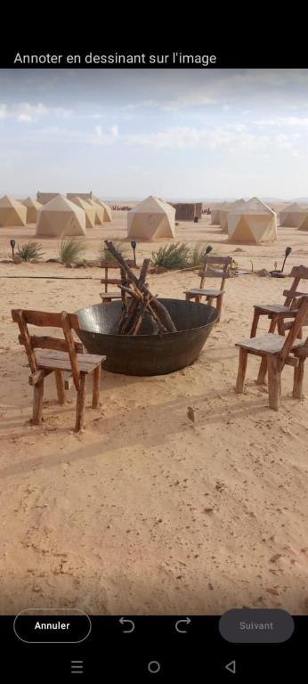a bowl and two benches in the desert at Camp ainelseid in Kebili