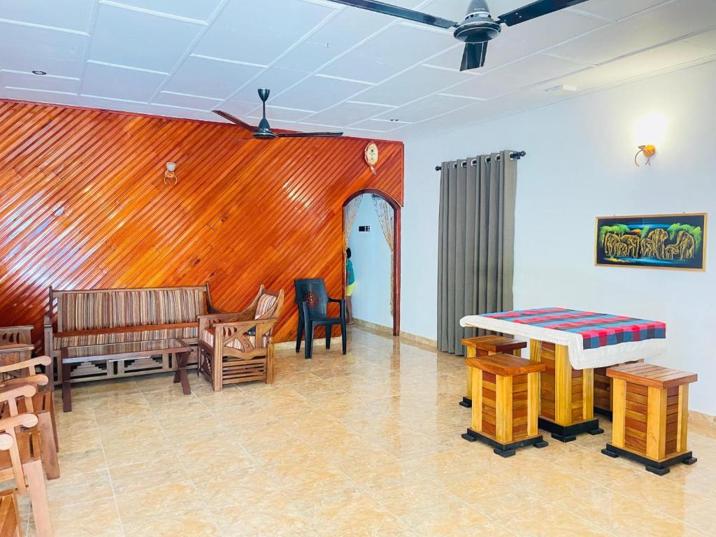 a living room with a table and chairs and a table and benches at Madu Villa in Weligama
