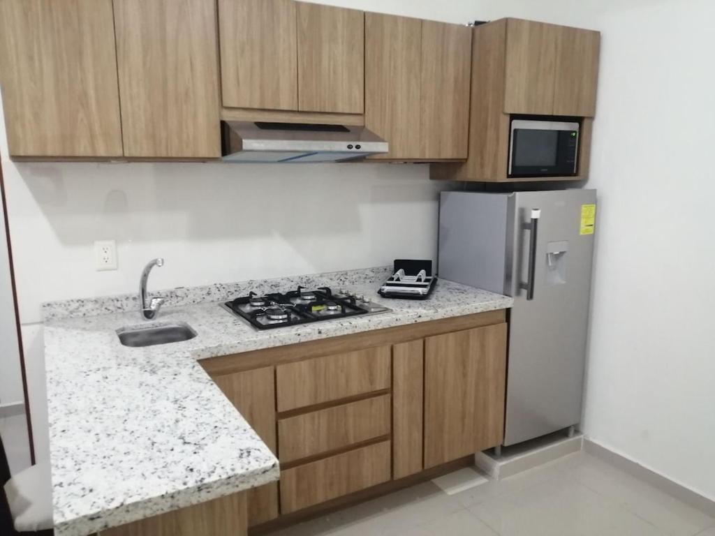 a kitchen with a stove and a refrigerator at Ciudad del Valle Departamento C in Tepic