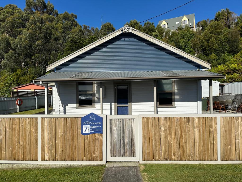 a house with a wooden fence in front of it at The Boat House in Strahan