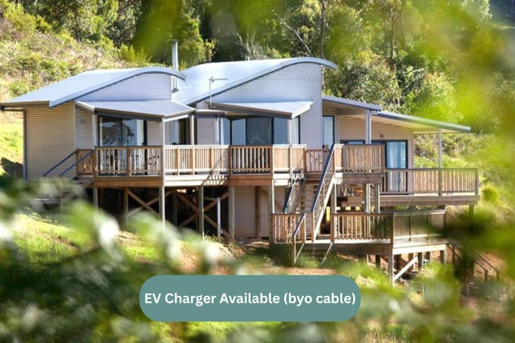 a house with a metal roof on a deck at Serendeva: Stunning views, private & EV charger in Denmark