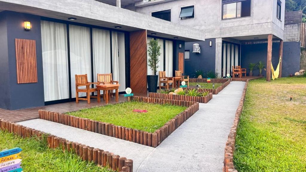 a house with a garden in the yard at Pousada Studio Siriú in Garopaba