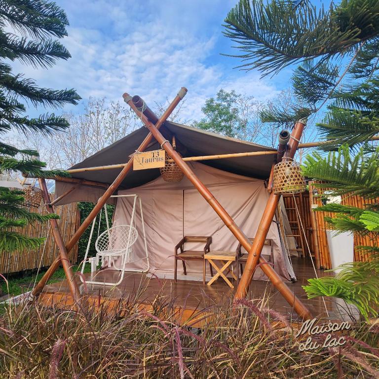 a tent with a table and chairs in front of it at Maison Du Lac The Safari Tent in Wang Nam Khieo