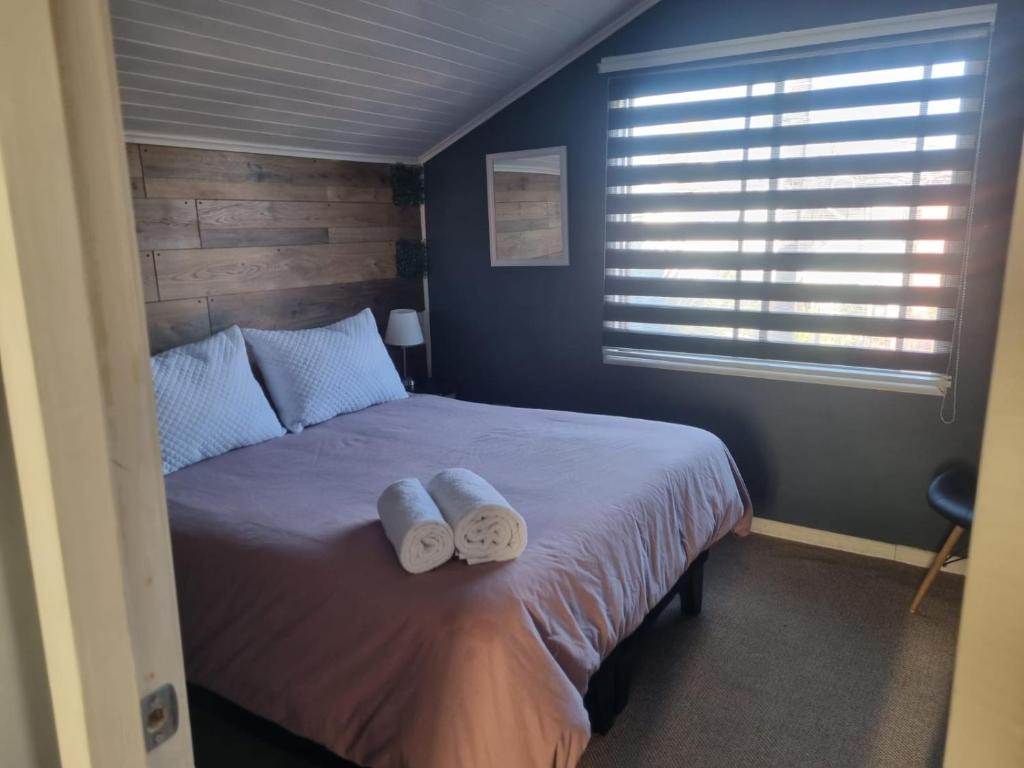 a bedroom with a bed with two towels on it at Los Camperos AR in Temuco