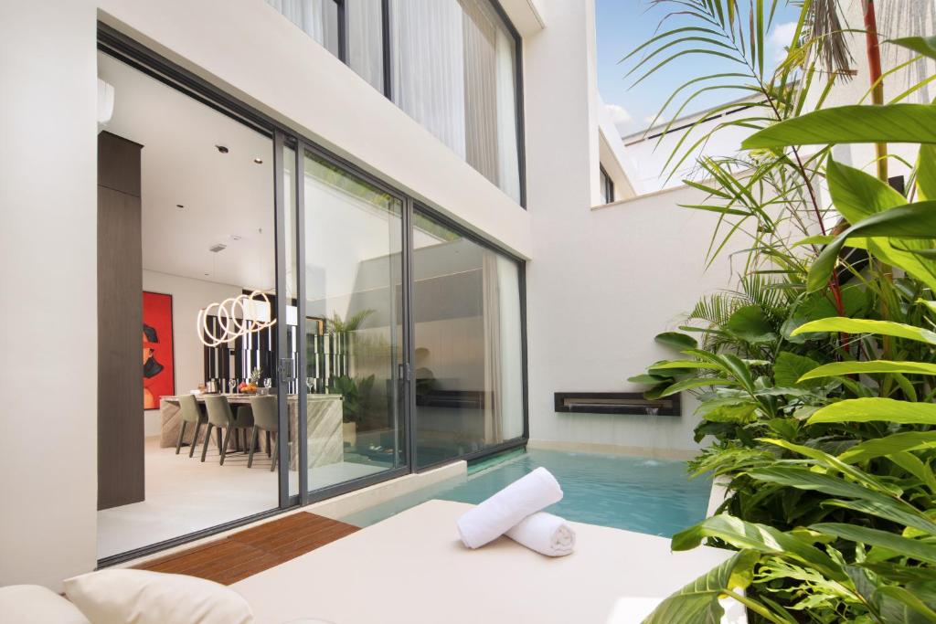 an indoor pool in a house with glass walls at Echo Beach Villas 6 in Canggu