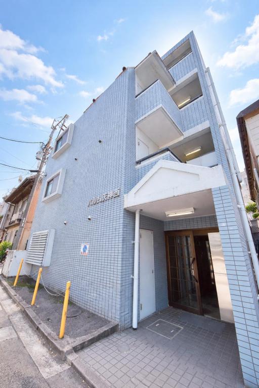a blue building with a staircase on the side of it at パルム天神西 in Susakiuramachi