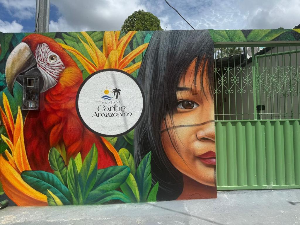 a wall with a painting of a woman and a rooster at Pousada Caribe Amazônico Alter do Chão - 1 quarteirão da Orla de Alter in Alter do Chao