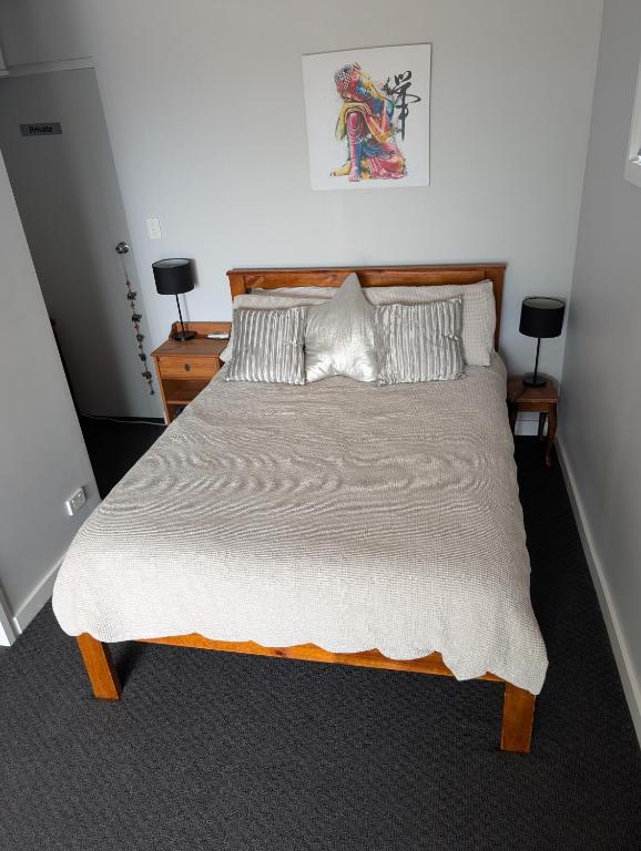 a bedroom with a large bed with two night stands at The Elephants Nest in Victor Harbor