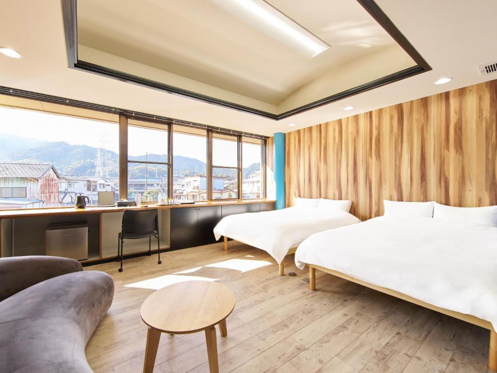 a hotel room with two beds and a desk at マーケットステイ新宮 in Shingū