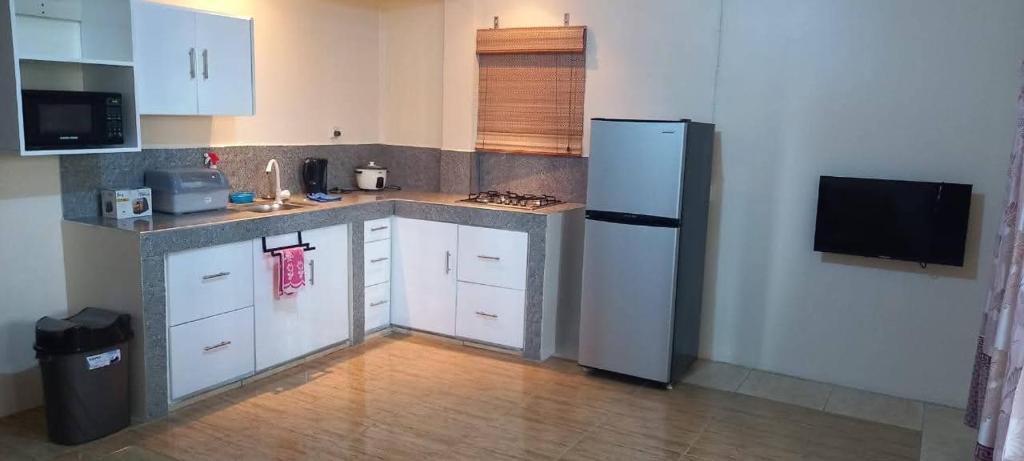 a kitchen with white cabinets and a refrigerator at Lotus Appartementen Nickerie in Majoor Fernandes