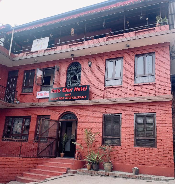 a red brick building with a sign on it at Rato Ghar Hotel and Rooftop Restaurant in Bhaktapur