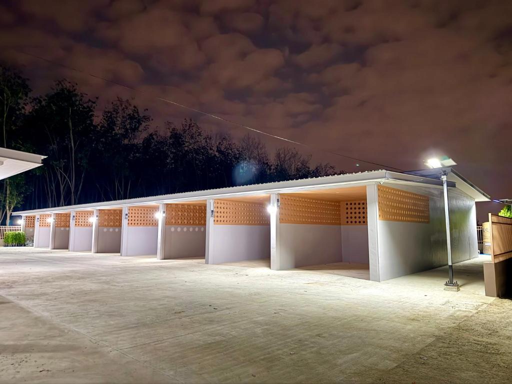 a large white building with a parking lot at night at Third Space House in Ban Nong Chaeng