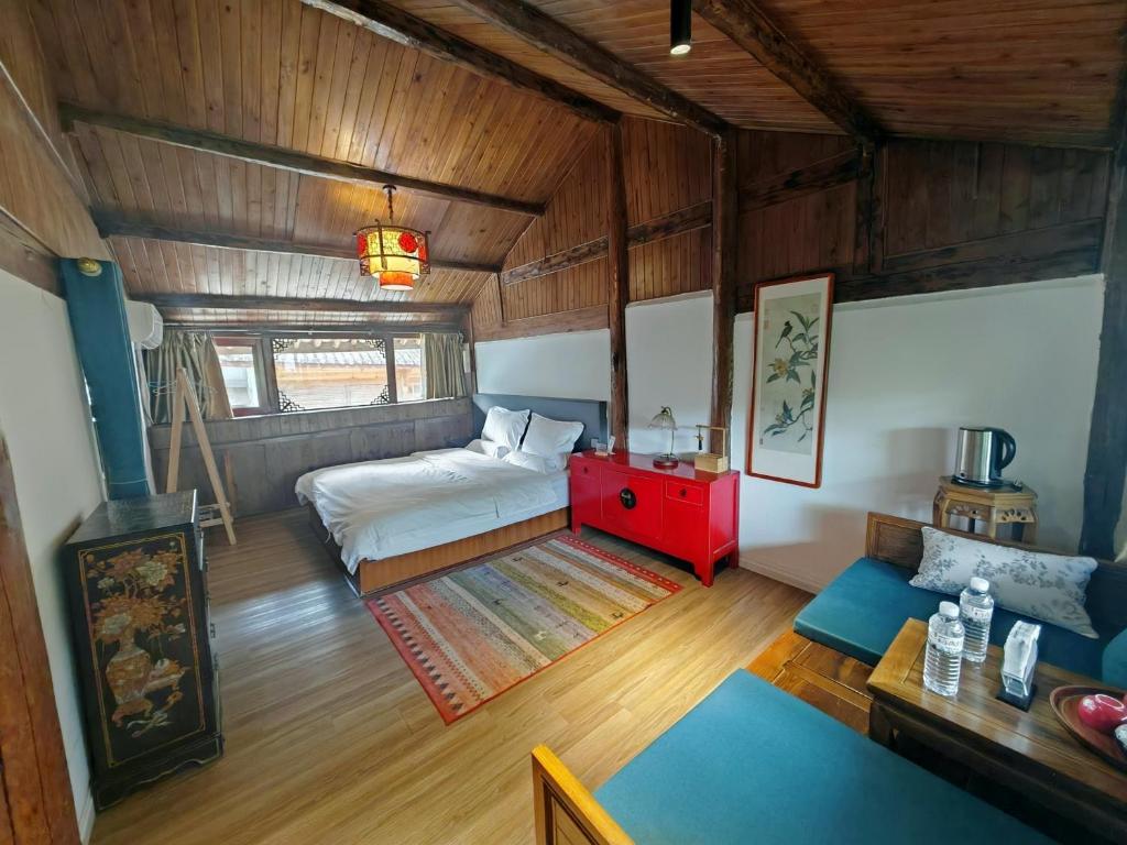 a bedroom with a bed and a table in a room at Baisha Holiday Resort Lijiang in Lijiang