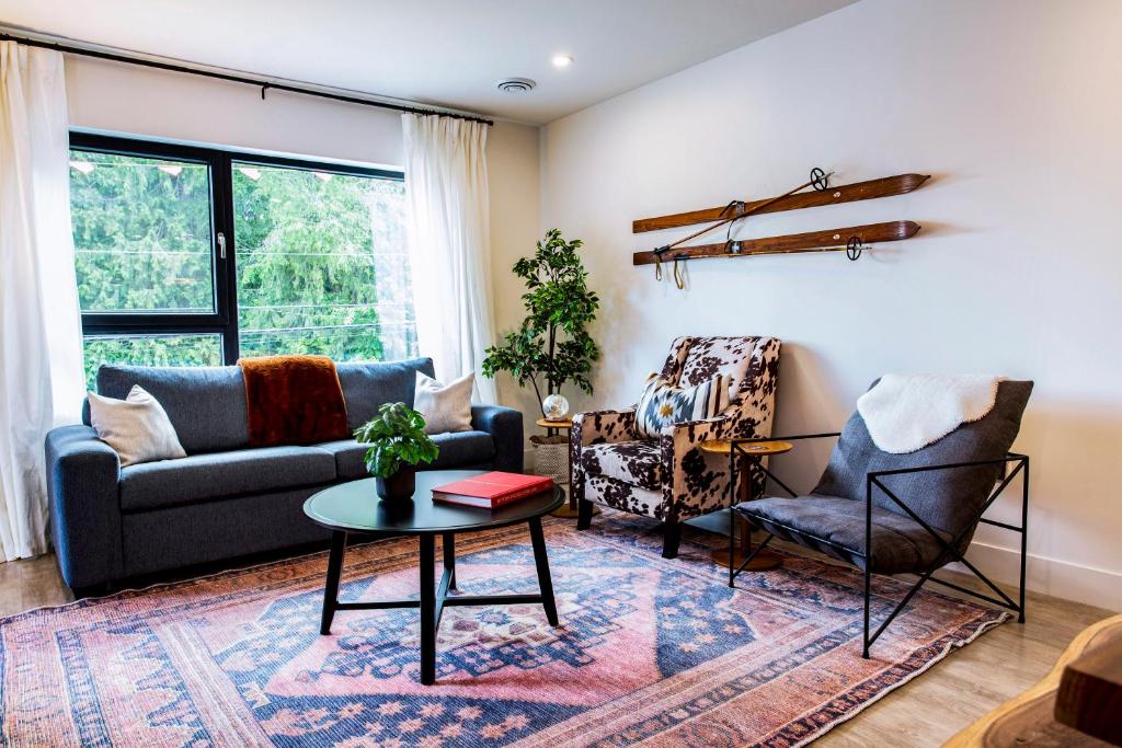 a living room with a couch and chairs and a table at Tucker's Place in Revelstoke