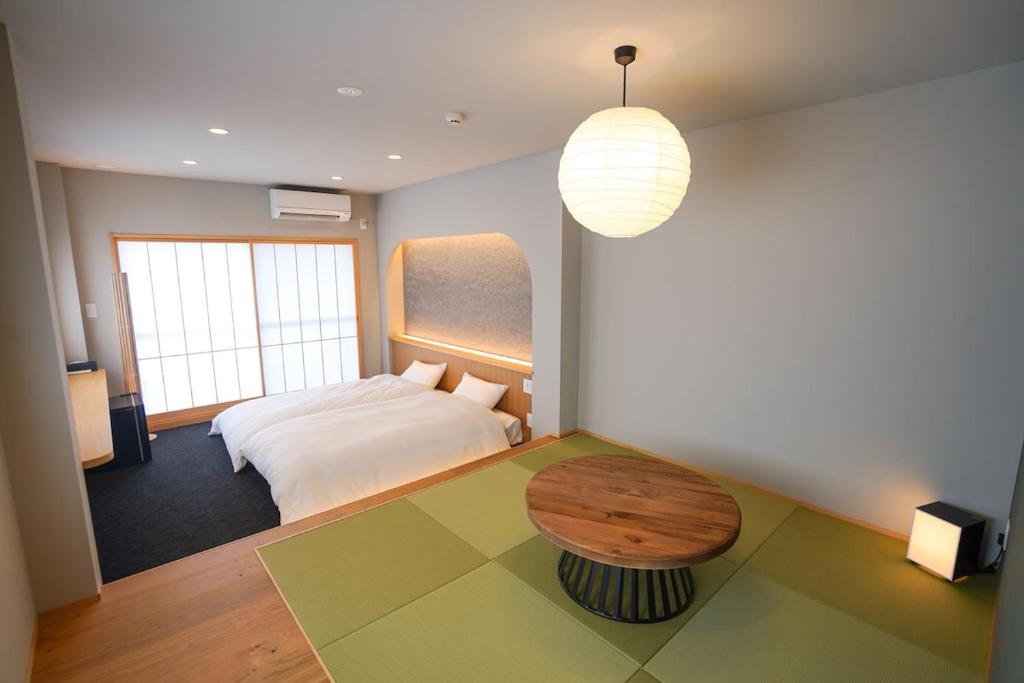 a bedroom with a bed and a table in it at ミツカビルヂング in Kofu