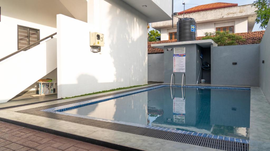 a swimming pool in front of a building at Rugee R Villa in Negombo