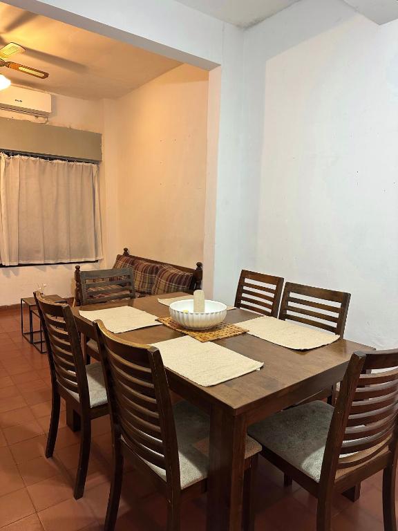a dining room with a wooden table and chairs at Apapacho Urbano Casa cómoda Ideal familias y grupos in Paysandú