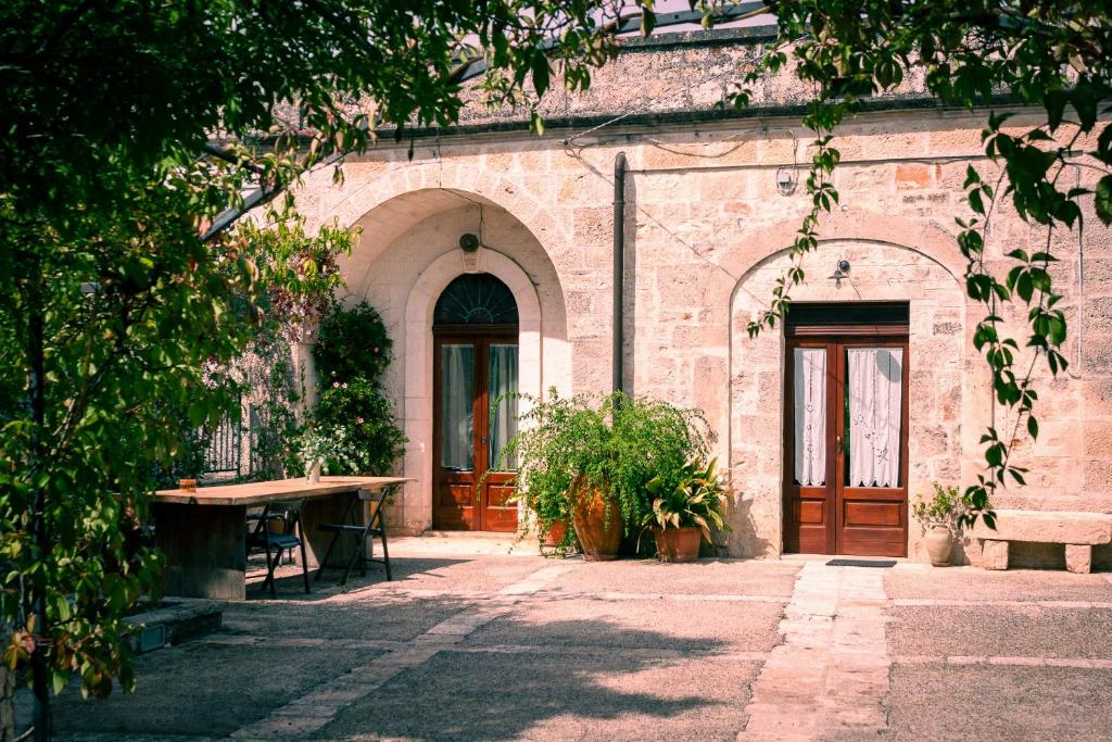 a brick building with a wooden door and a table at House With Jacuzzi Among Orchards In Cisternino in Cisternino