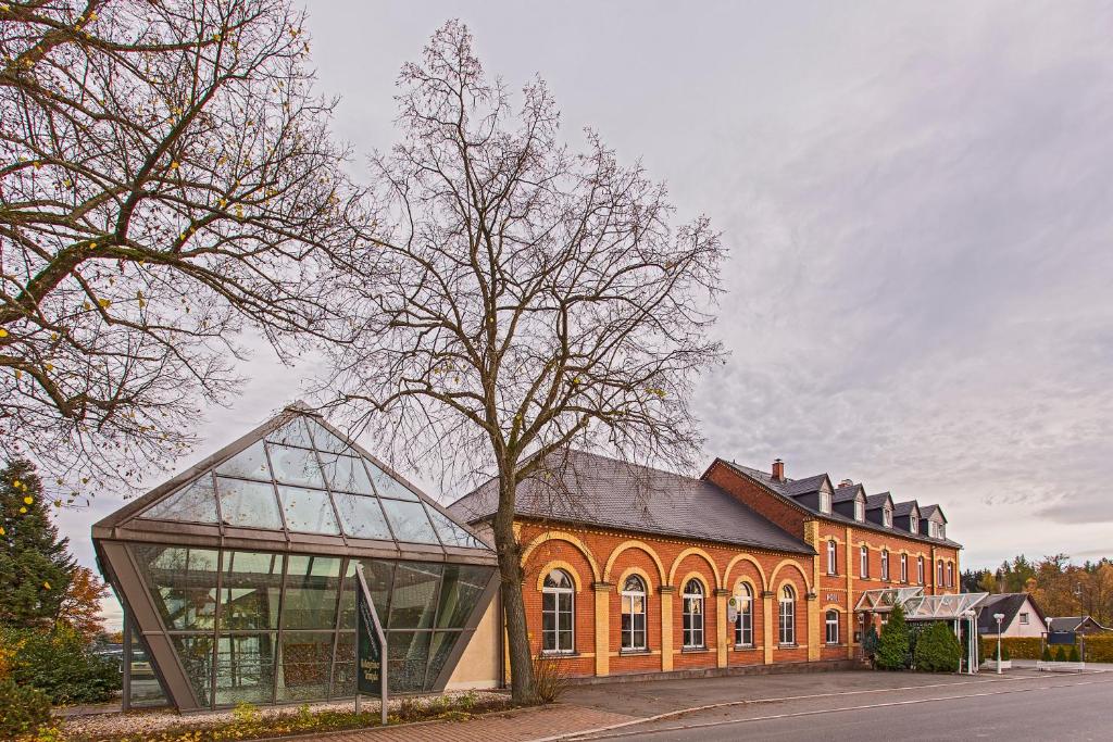 een groot oranje gebouw met een boom ervoor bij Der Bayerische Hof in Grünbach