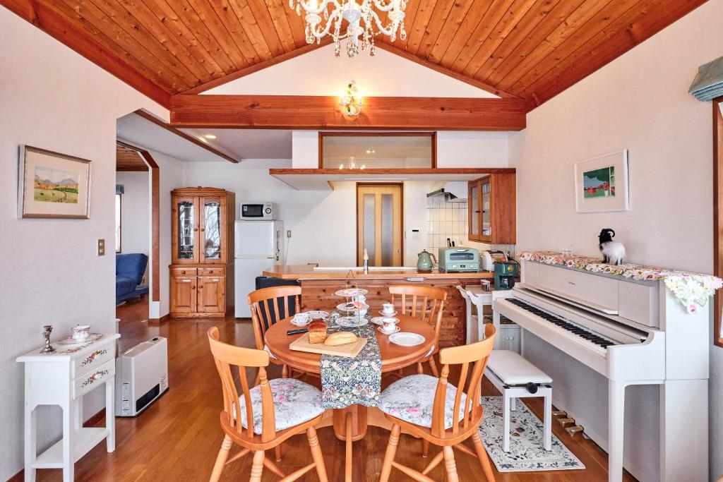 a kitchen and dining room with a table and a piano at holidayhouse SERENADE in Nasu
