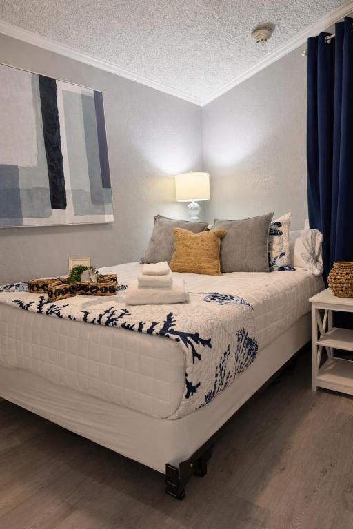 a large white bed in a room with blue curtains at Luxury Beach front Condo in Galveston